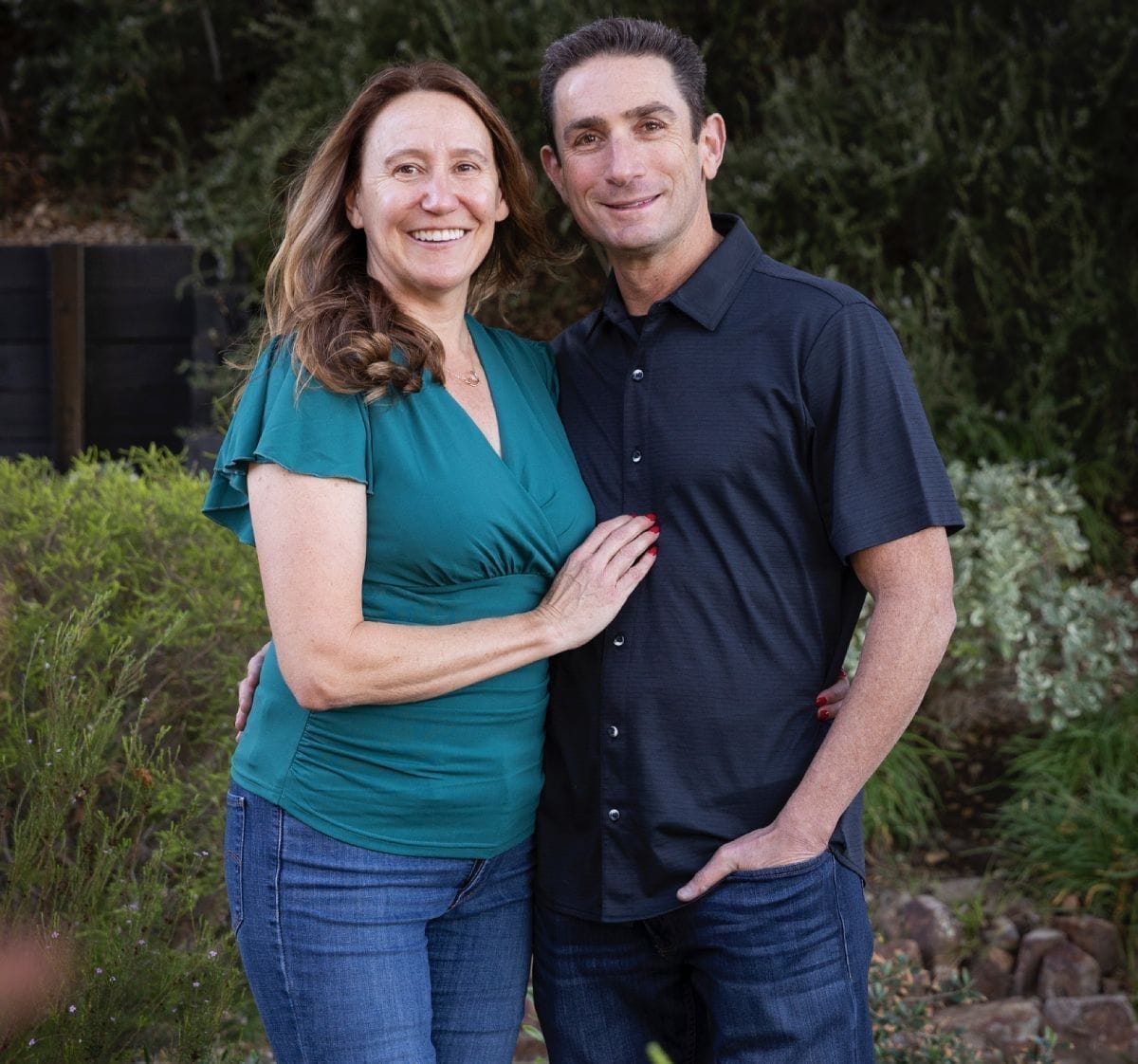 man holding hand of woman standing near tree